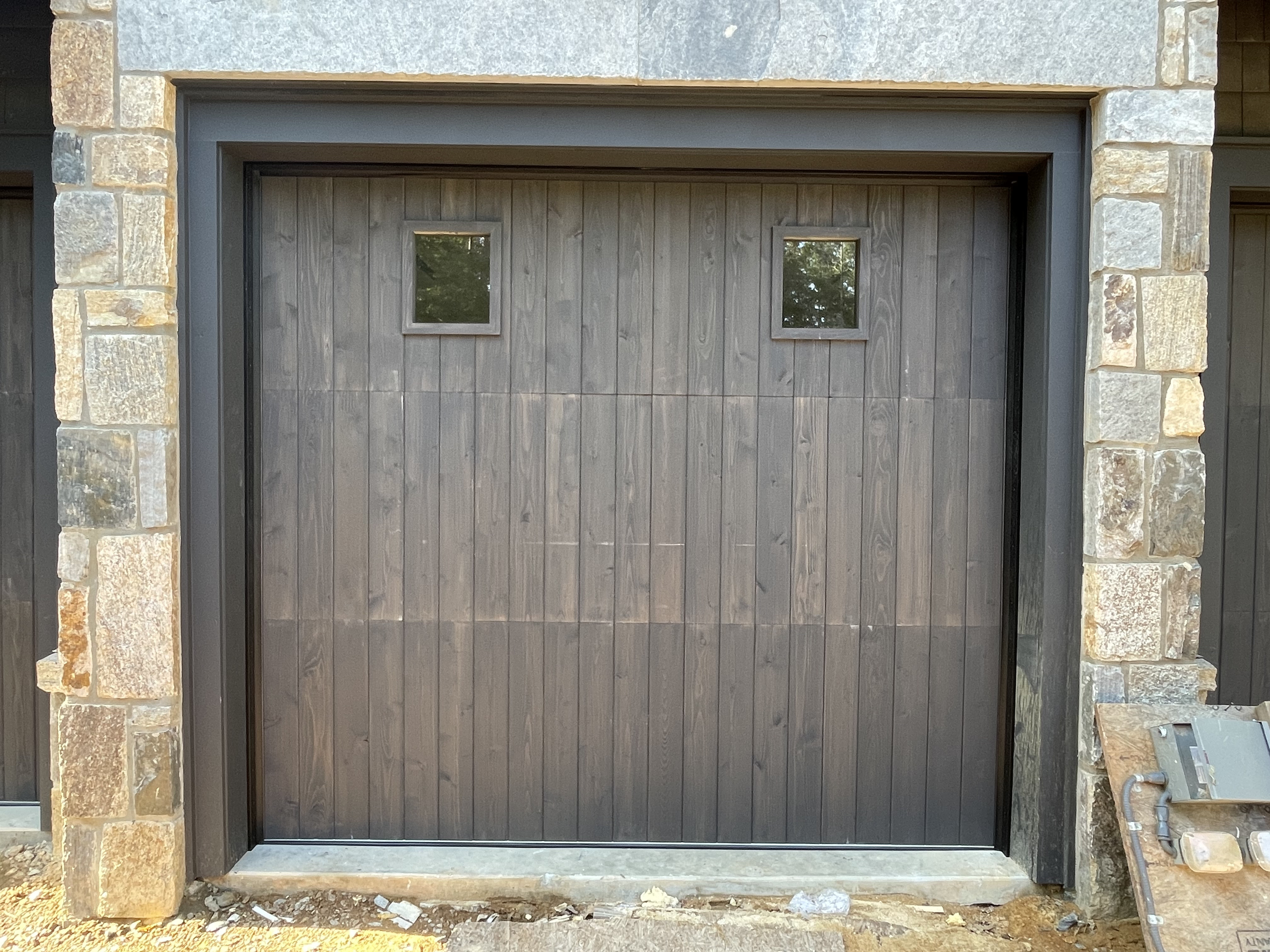 Custom dark stained vertical plank wooden garage door with small windows by Old Wood Dynasty