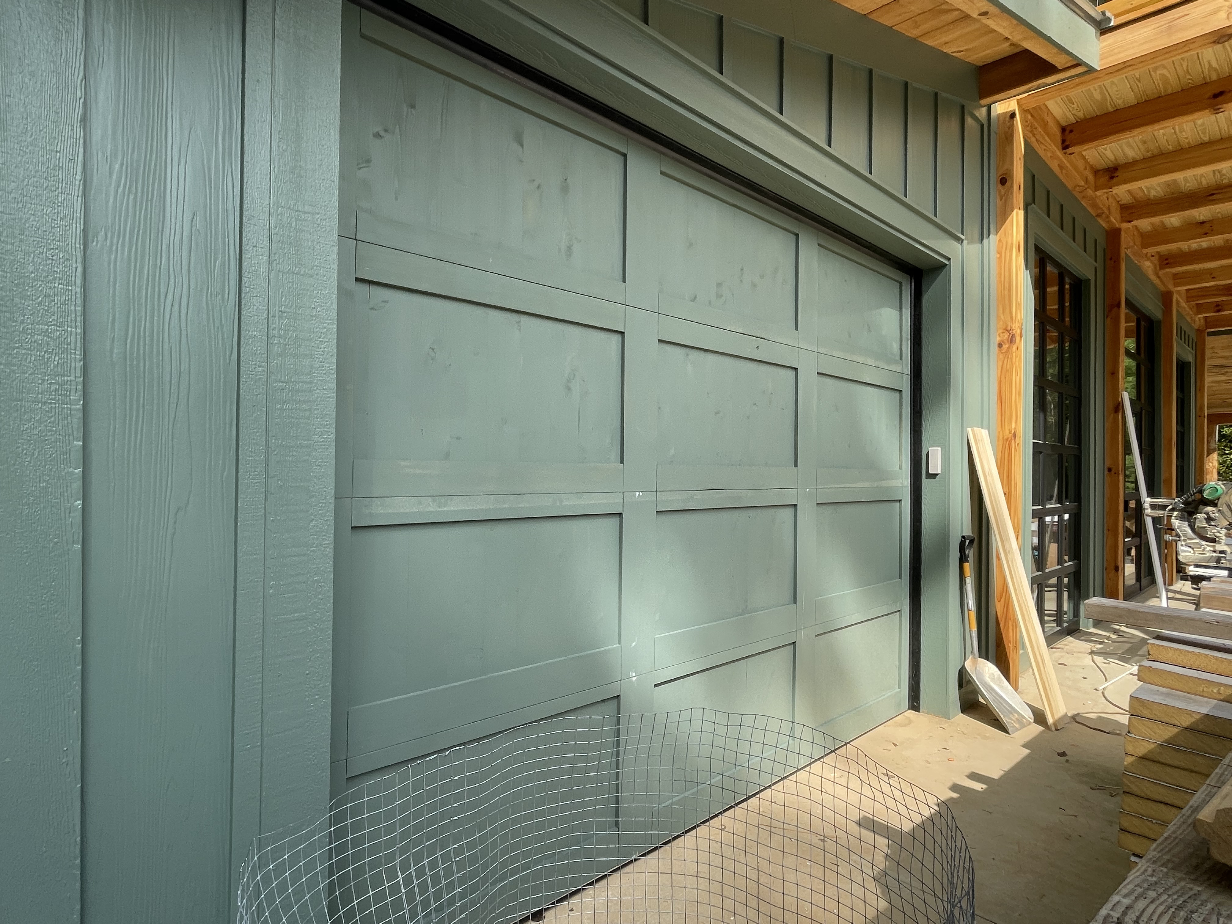 Custom painted wood panel garage door with matching house siding by Old Wood Dynasty