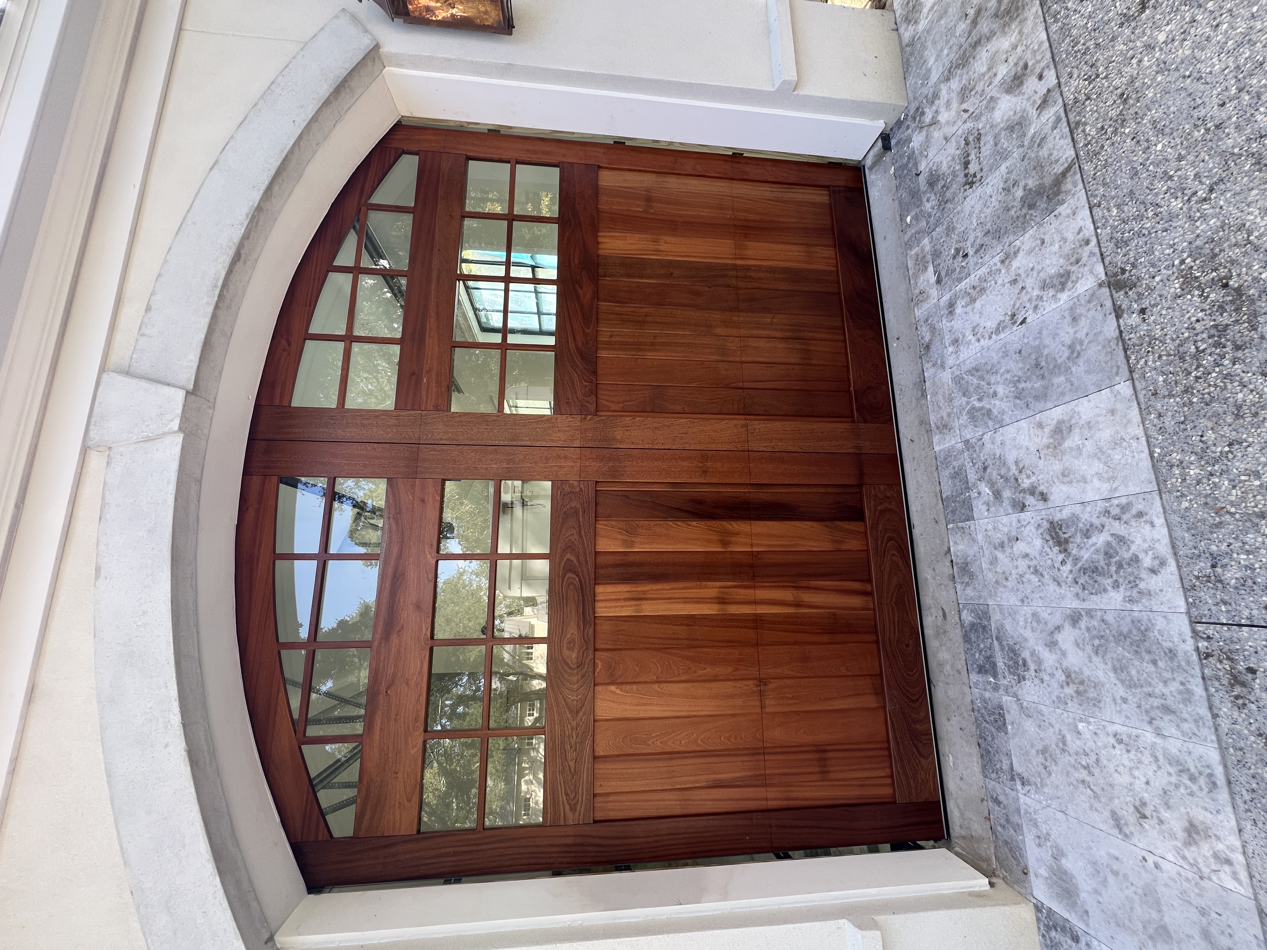 Custom sapele arched wooden garage door with gridded windows closeup by Old Wood Dynasty